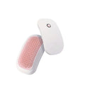 Light pink handheld electric vibration brush for grooming cats and dogs on a white background.