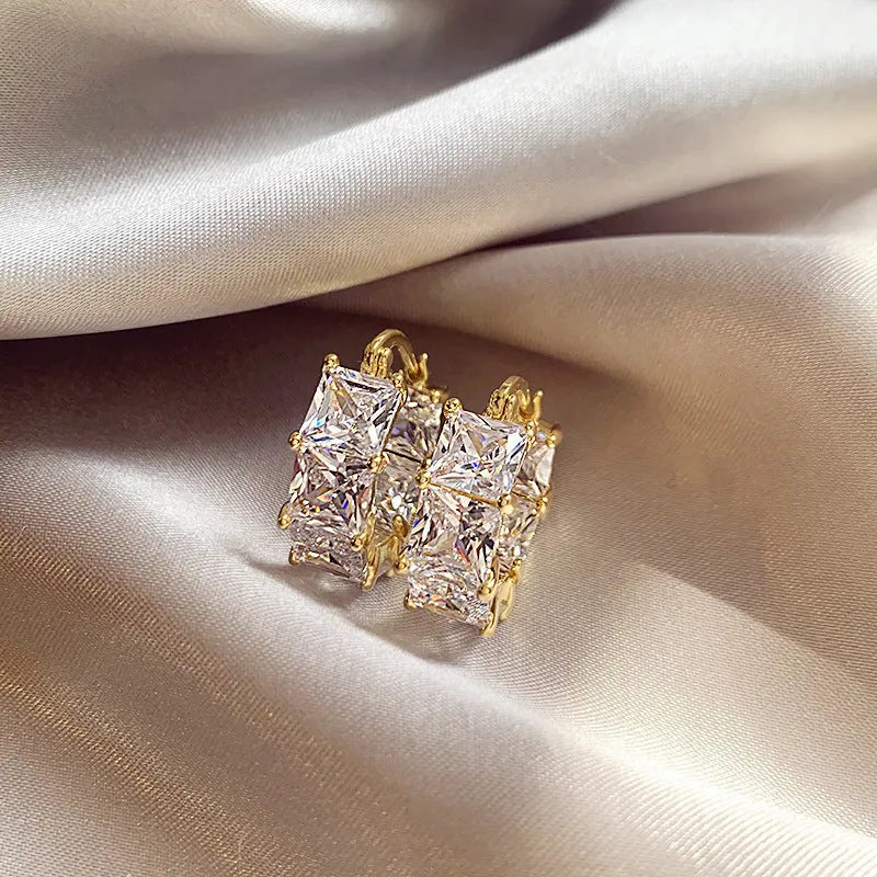 Geometric U-shaped gold earrings with black zircon crystal stones and round decorative elements