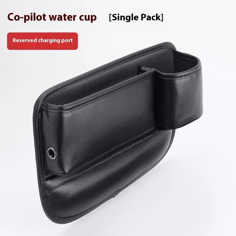 Car seat gap storage box with water cup holder in black leather beside driver seat