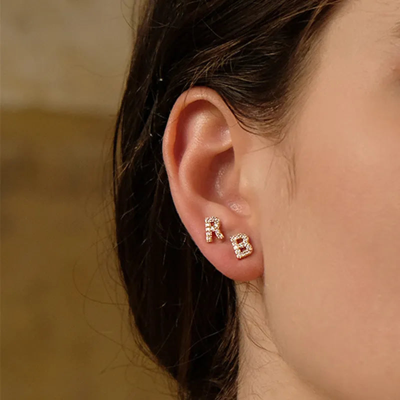 Brass gold plated alphabet earrings showing zircon letter detailing on copper base with gold plating