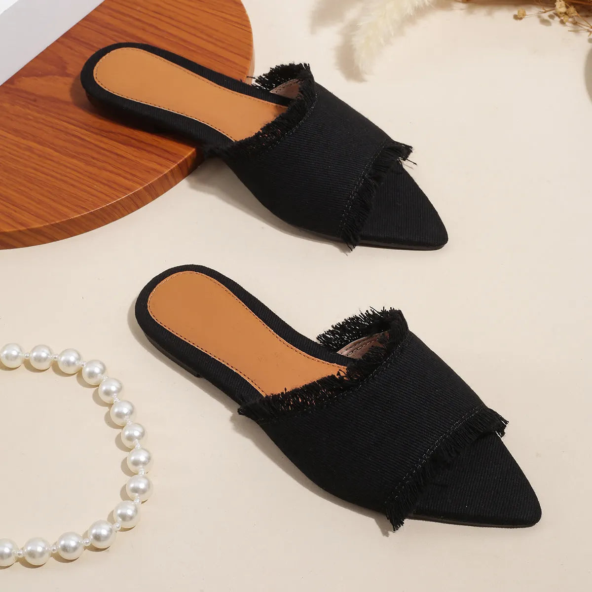 Women's denim flat slippers with a tassel, leather lining, and a PVC sole in various colours.