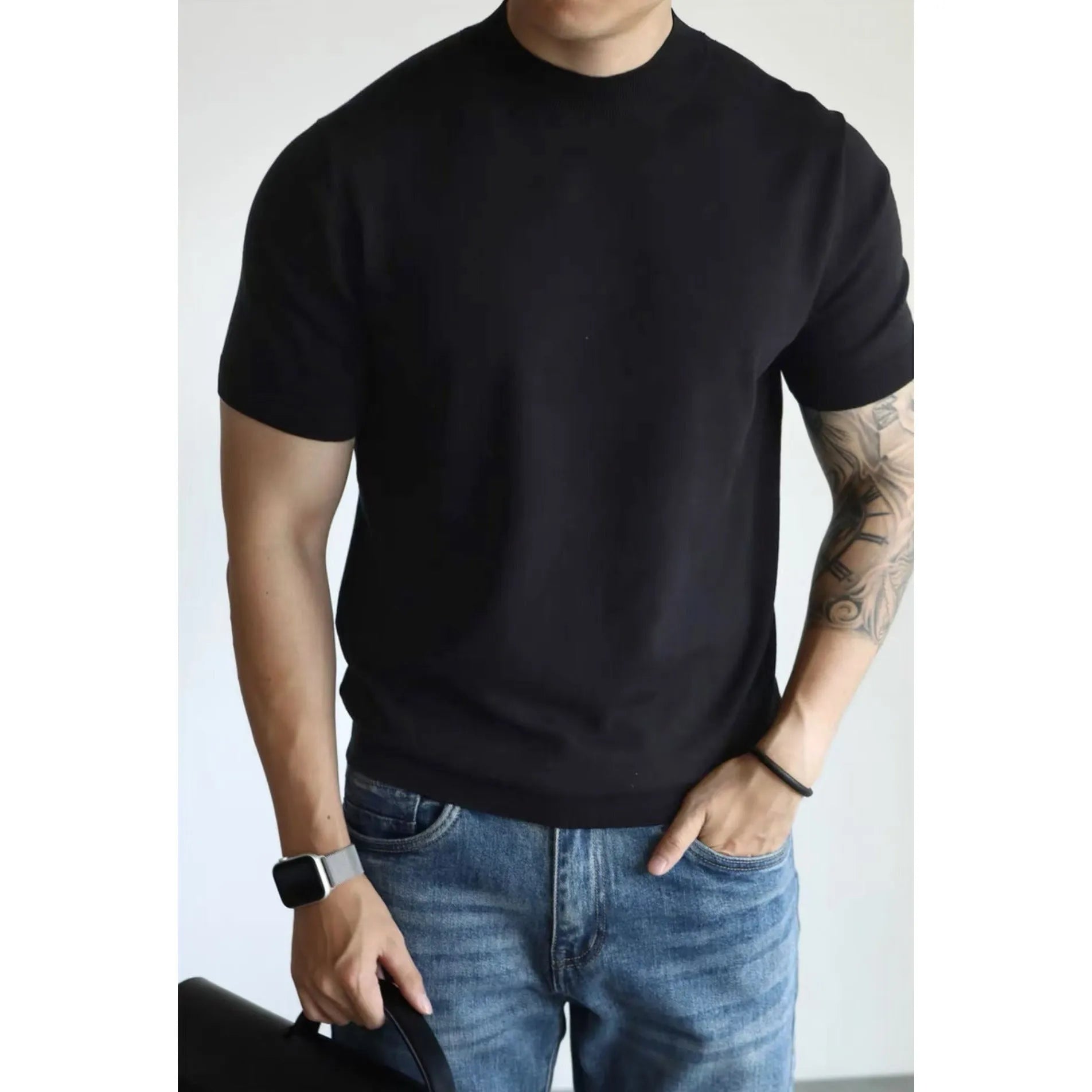 Man wearing a slim-fit solid colour polyester t-shirt, showcasing its lightweight knitwear construction.