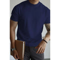 Man wearing a slim-fit solid colour polyester t-shirt, showcasing its lightweight knitwear construction.