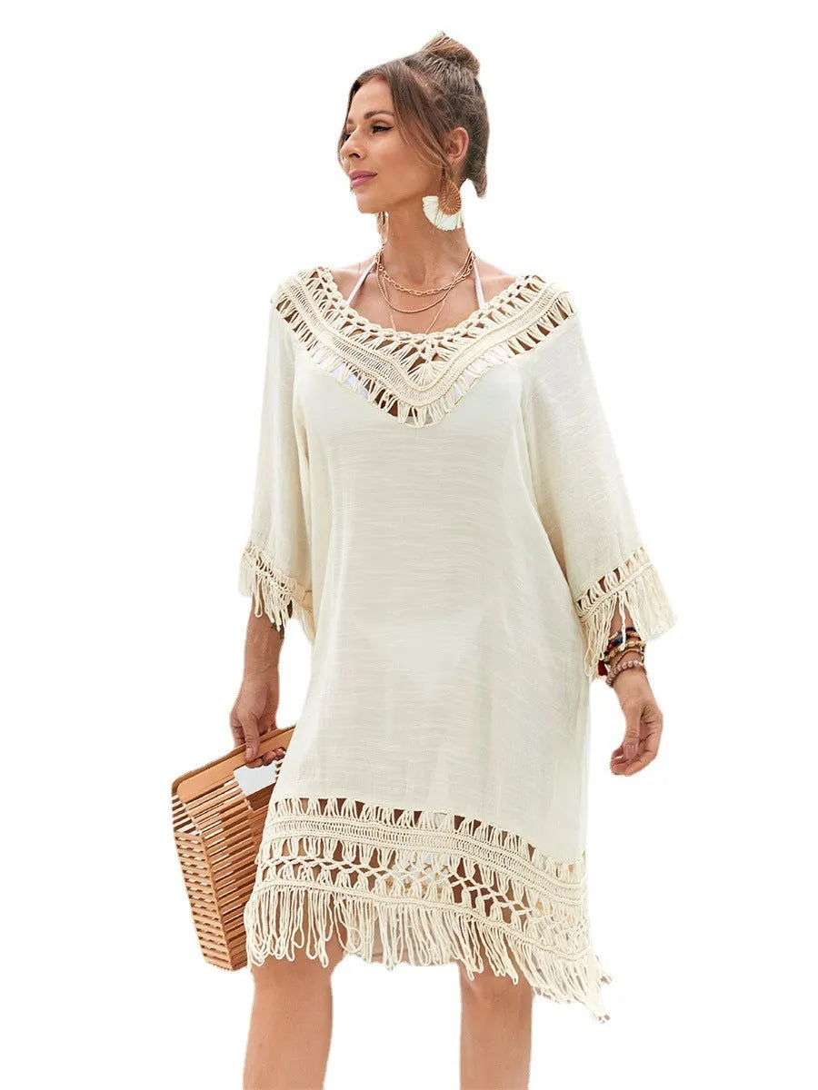 Apricot-coloured hand-crocheted long beach dress for women on a hanger.