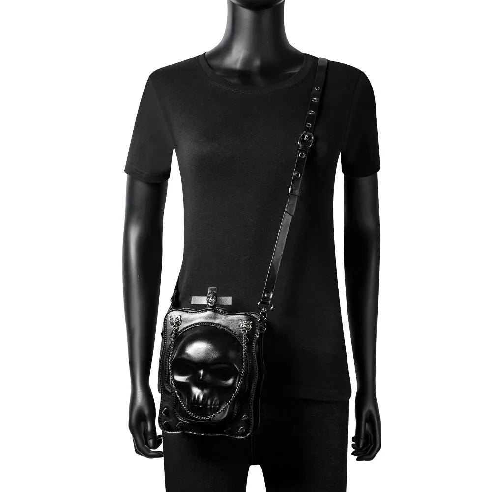 Black mini square crossbody bag with 3D embossed skull design, stitching details, and metal rivets