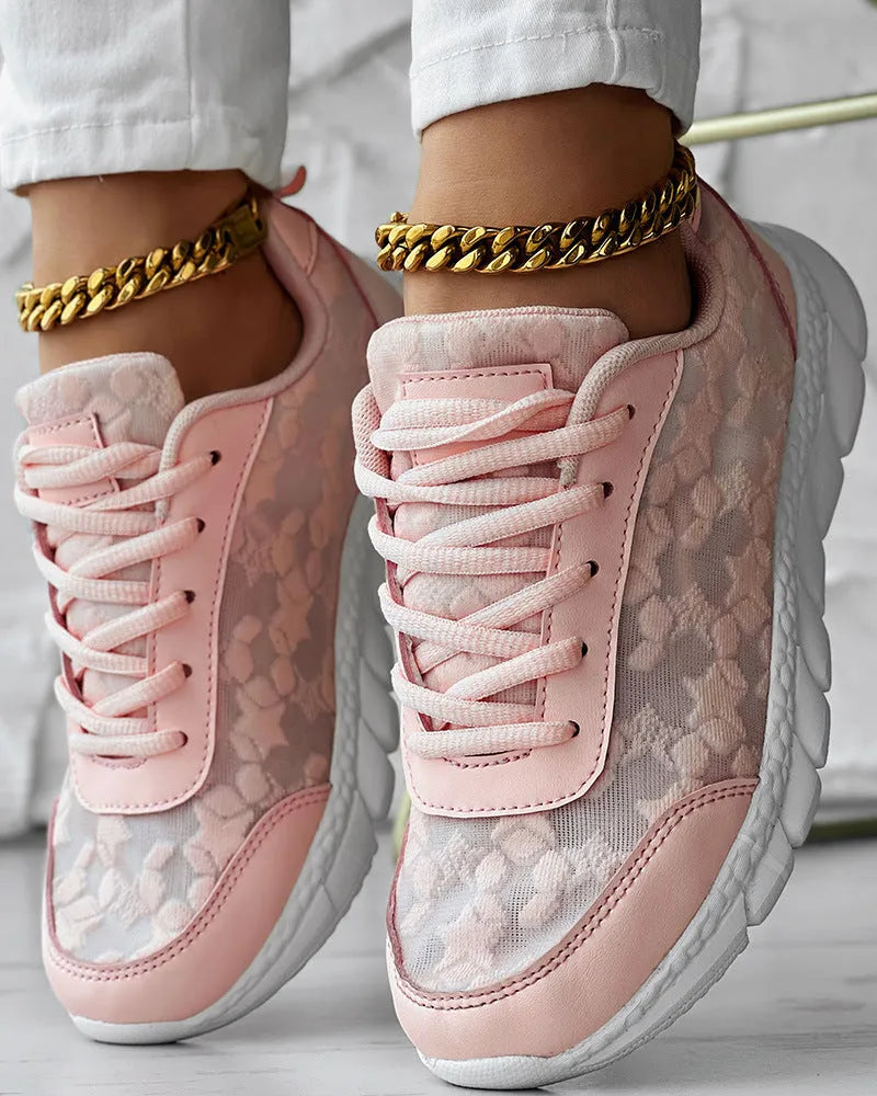 Women's white canvas running shoe with flat heel and soft sole on a light background.
