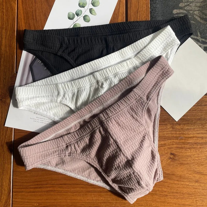 Men's solid colour cotton triangle briefs in mid-waist style, shown in apricot and black colour options.