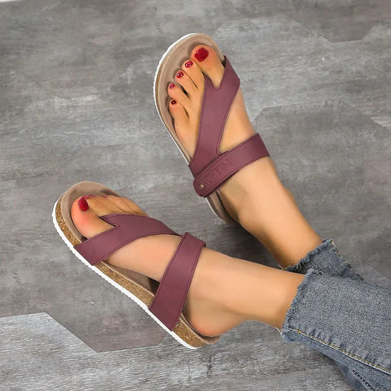 Thick-soled blue flip-flops with flat toe ring design on beach background