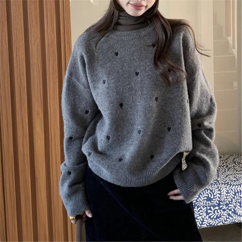 Women's loose fit acrylic pullover sweater with embroidered love pattern in milky white.