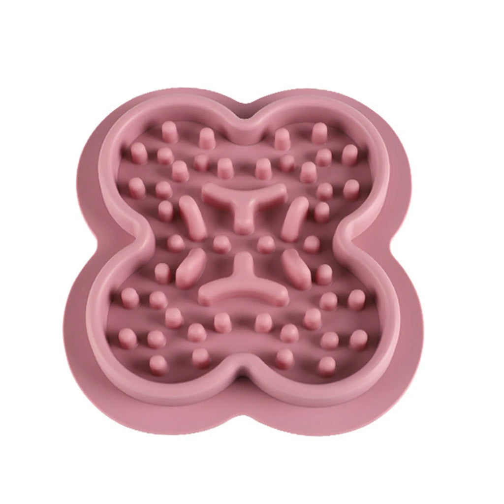 Silicone pet slow feeder licking mat with raised edges in assorted colours on a kitchen floor.