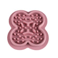 Silicone pet slow feeder licking mat with raised edges in assorted colours on a kitchen floor.