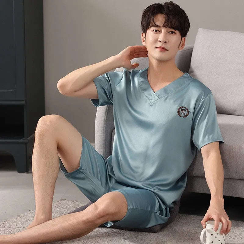 Man wearing a light grey ice silk short-sleeve pajama shirt and matching loose shorts.