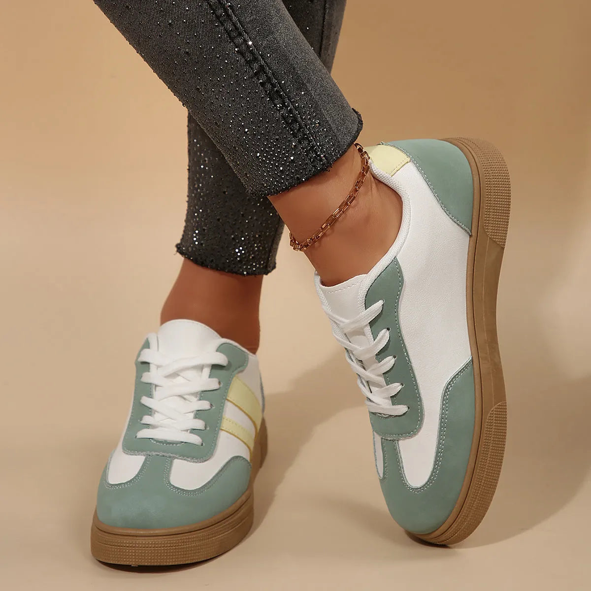 Green women's retro trainers with a cross strap design, round toe, and white rubber sole.