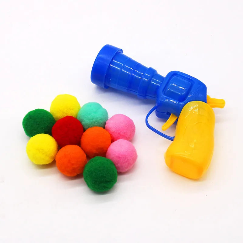 Plush cat toy launch gun with soft yarn balls for interactive indoor pet play.