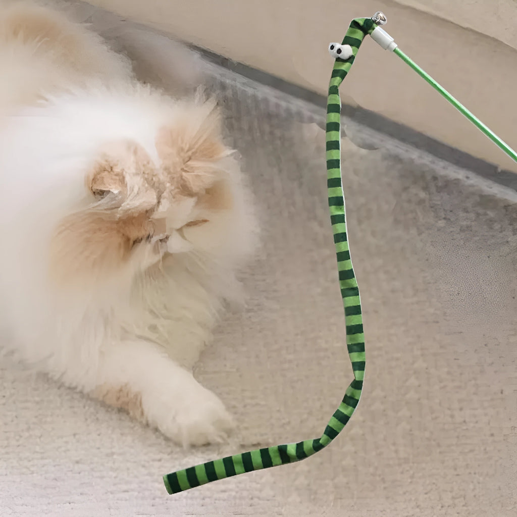 Colourful cat teaser wand with a long plush strip and a bell, held by a person.
