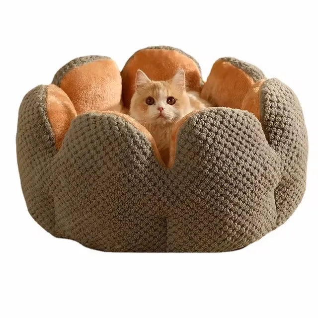Green cactus petal shaped plush dog bed with a non-slip bottom on a wooden floor.