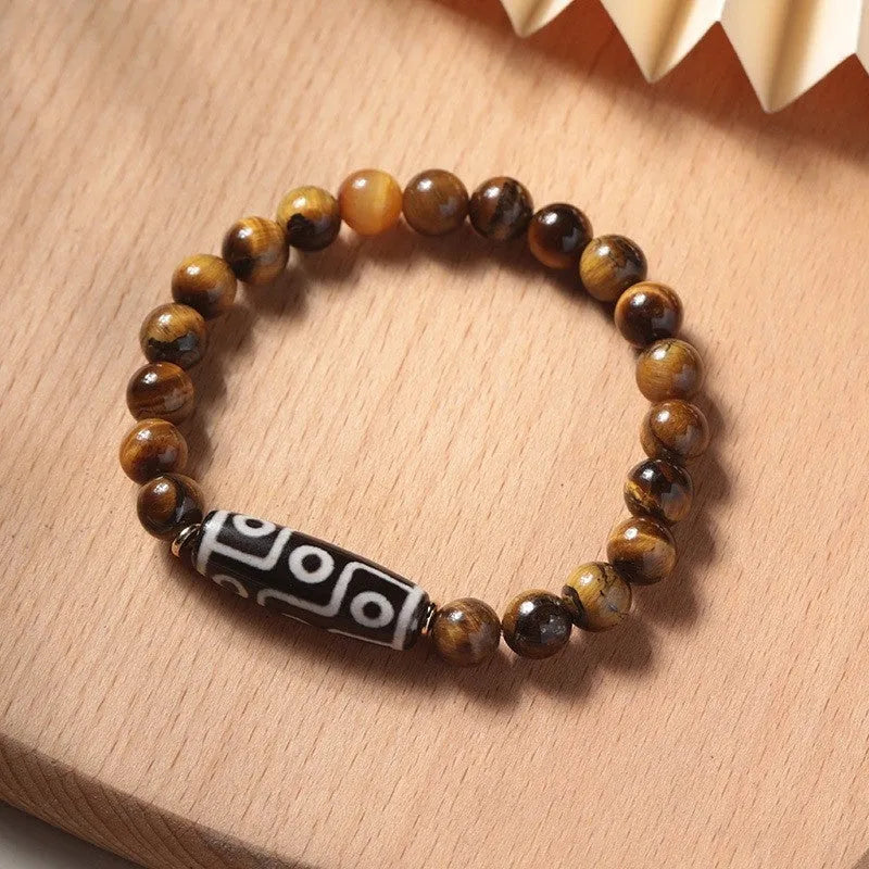 Single circle tigereye stone Buddhist prayer beads bracelet on wrist, showing ethnic design.