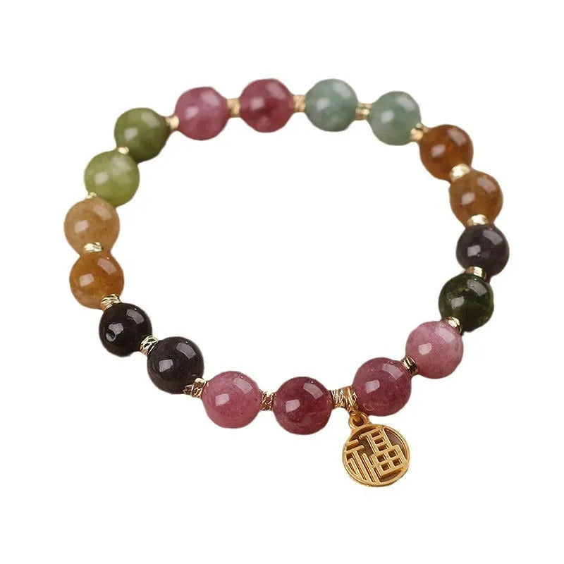 Natural colour tourmaline bracelet with floral beads and geometric design on wrist