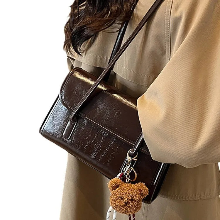 Brown women's PU leather shoulder bag with a square shape, double straps, and a detachable pendant.