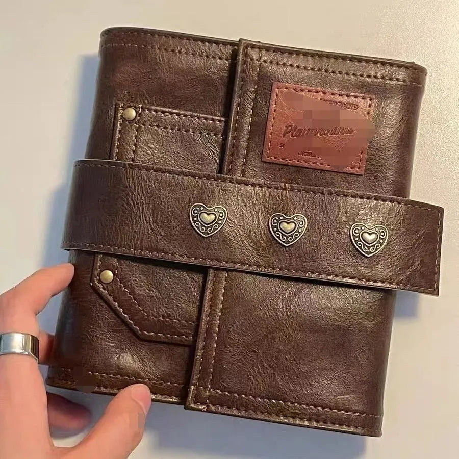 Brown PU cover A7 notebook with metal buckle closure showing loose-leaf binding and raw wood pulp pages