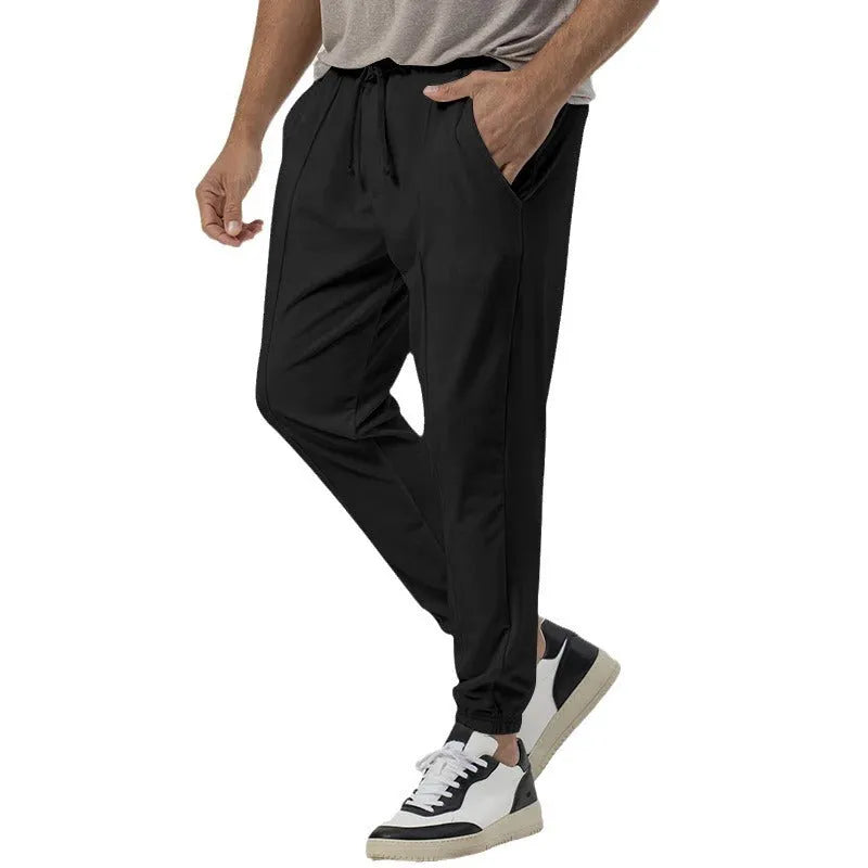 Men's grey track sweatpants with elastic waistband and straight-leg tapered fit