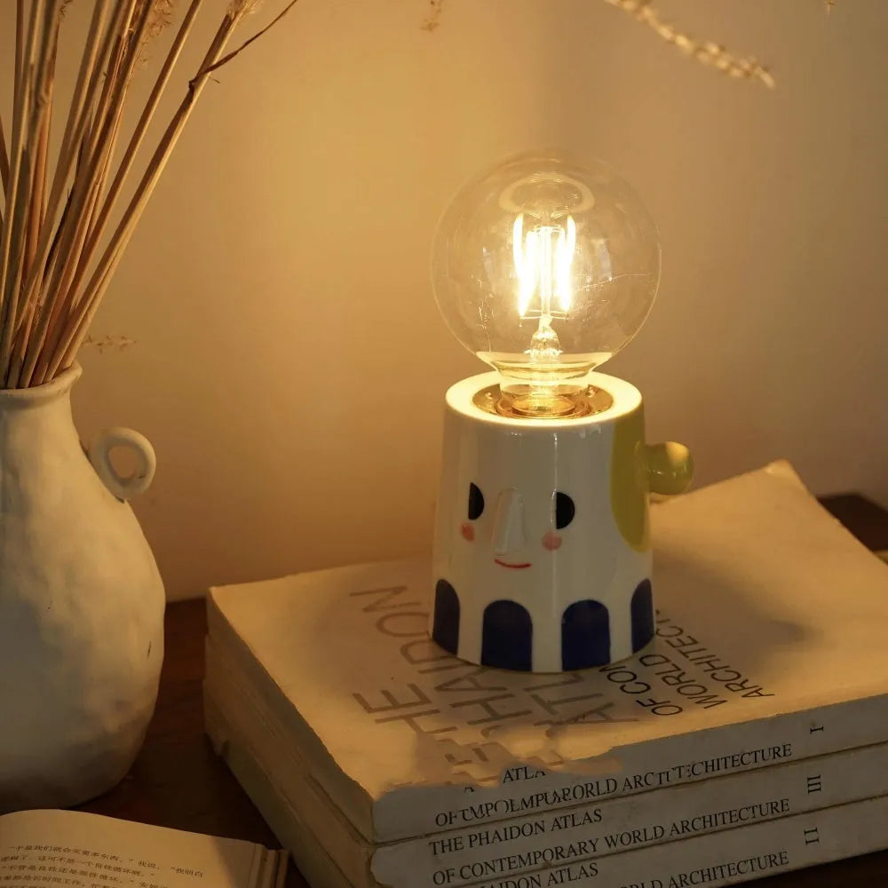 Handmade ceramic table lamp with ball headlight design on wooden surface