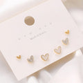 Set of three pairs of women's heart-shaped alloy drop earrings in gold, black, pink colours.