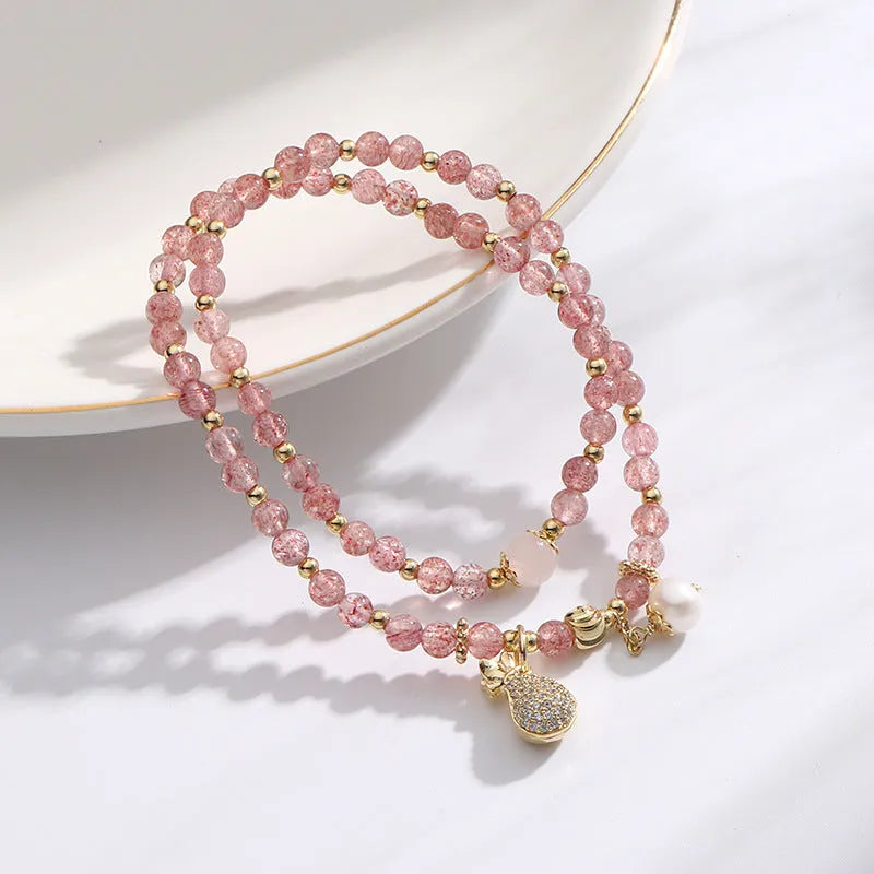 Women's strawberry quartz bracelet with geometric wallet-style design and adjustable beaded construction