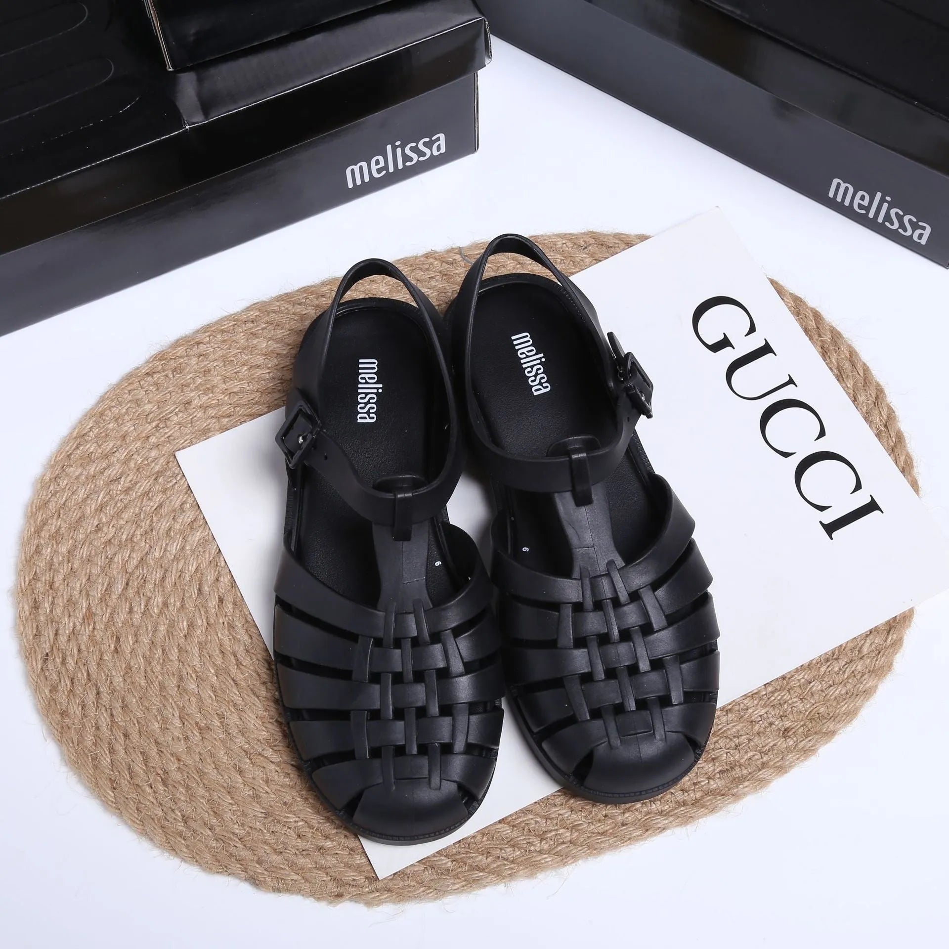 Matte black Roman sandals with vintage weave pattern and buckle closure