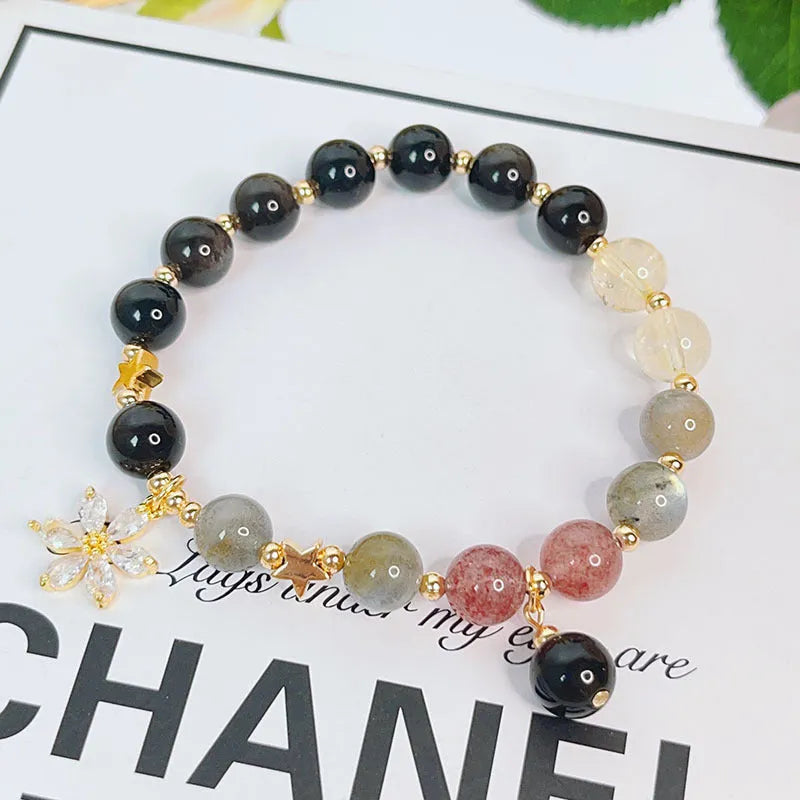 Adjustable silver stone bracelet for women with choice of flower, love, or star charm on a white background.
