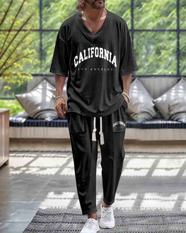 Thin polyester trousers suit with V-neck cropped sleeve jacket and matching trousers on a hanger.