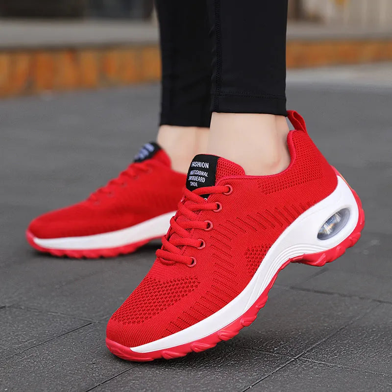 Red and black women's low-top mesh sneakers with round toe and front lace-up closure.
