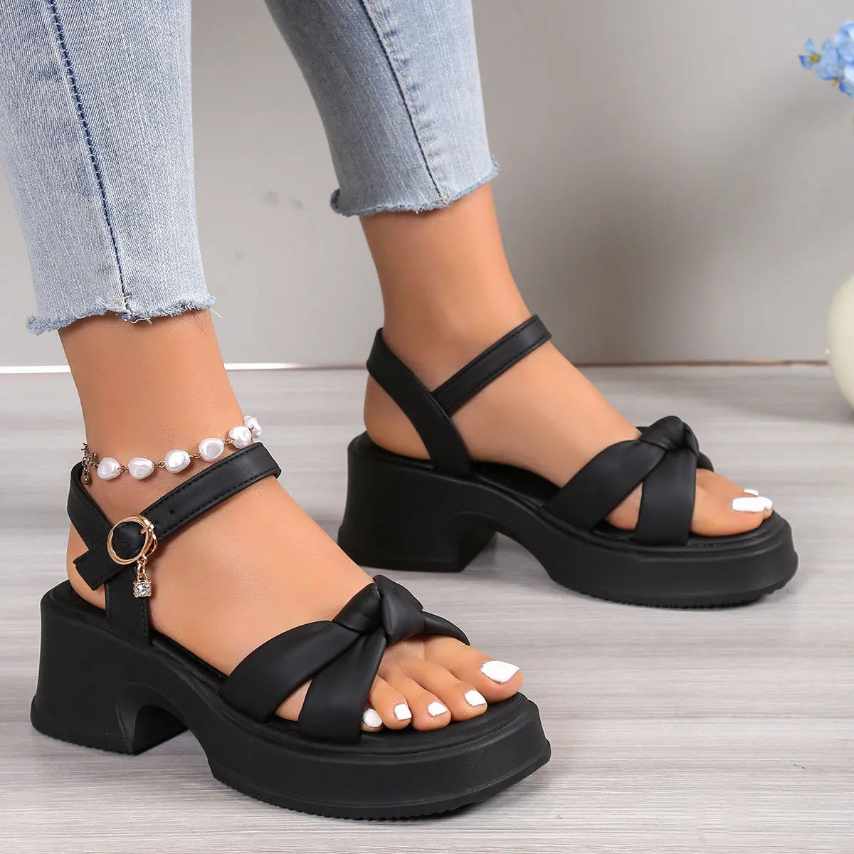 Women's black thick-heel slippers with a button fastening and round toe on a rubber sole.
