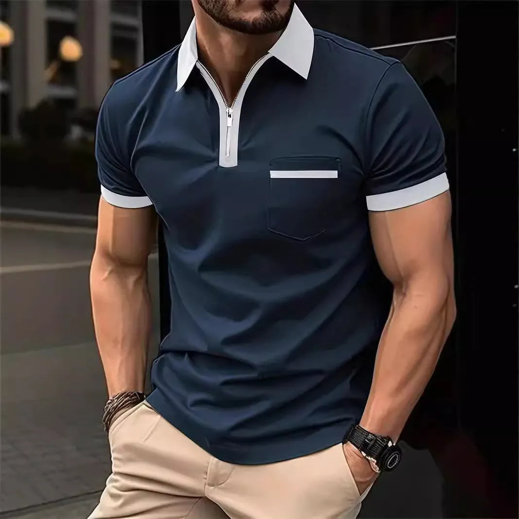 Man wearing a grey and navy blue casual t-shirt with a chest pocket and silver zip decoration detail.