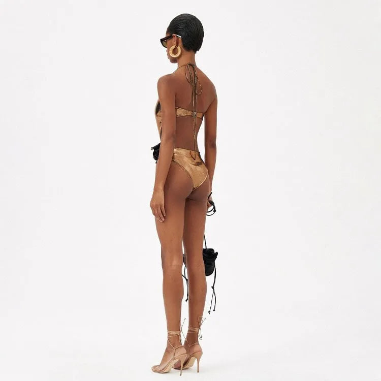 Gold coloured handmade one-piece swimsuit with halter neck and hollow out pattern.