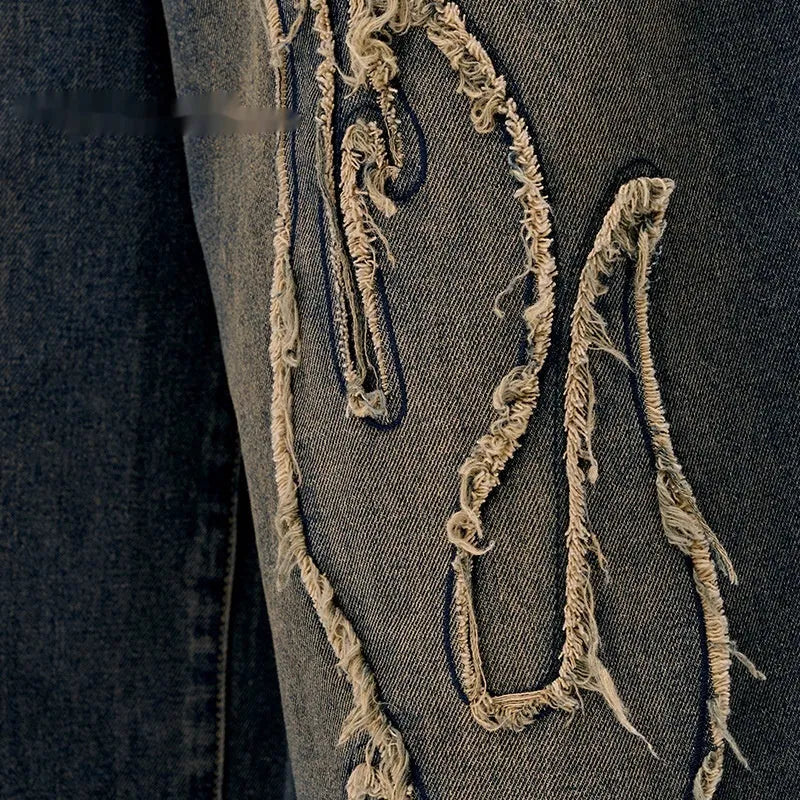 Men's black denim shorts with flame embroidery patches on the legs, showing a cropped, straight-leg cut.