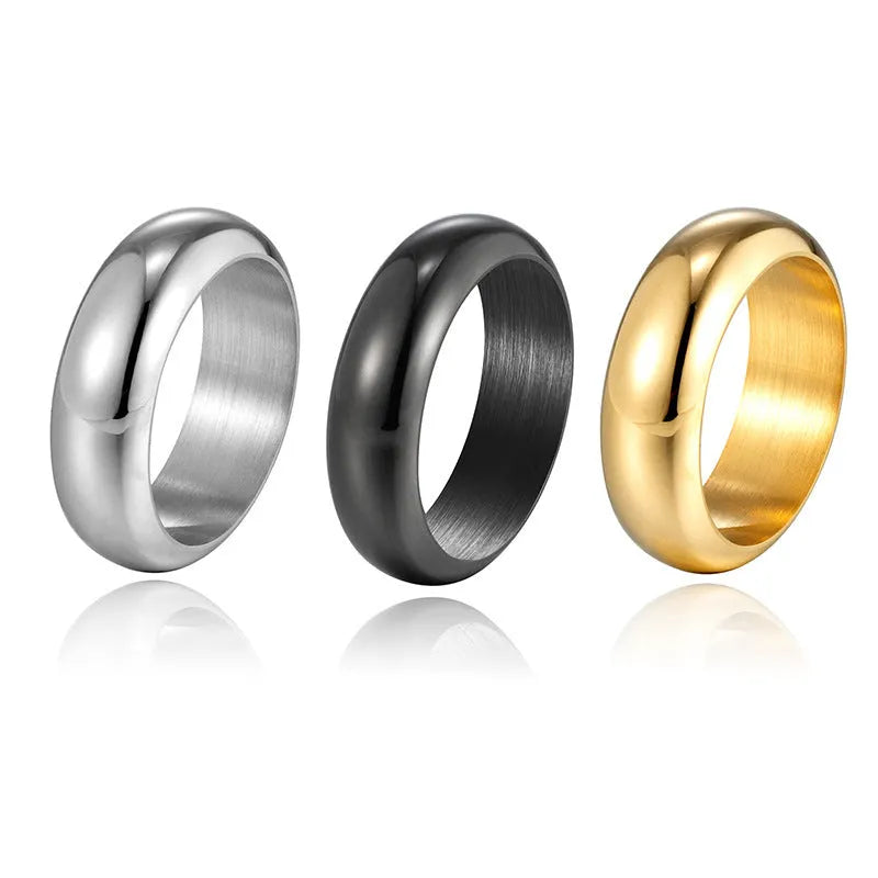 Glossy electroplated titanium steel ring in gold, black, and steel colours on a grey background.