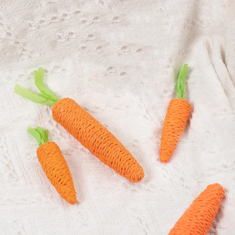 Set of assorted cat toys including fabric carrot bites, crinkly paper toys, ringing stones, feather-like sticks, and chewable tooth grinding sticks.