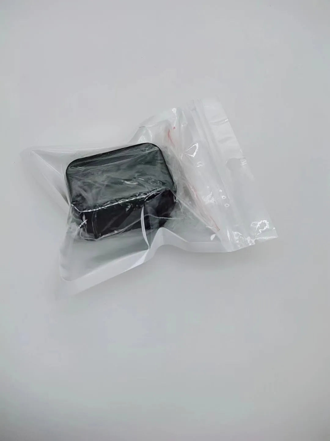 Black and red plastic seat belt buckle protective clamp holder device on a car seat.