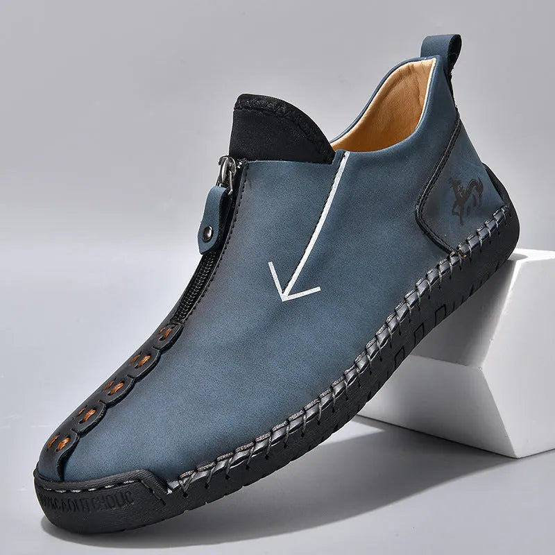 Men's black front-zip casual boots with round toe and low heel, showing the side zipper and rubber sole.
