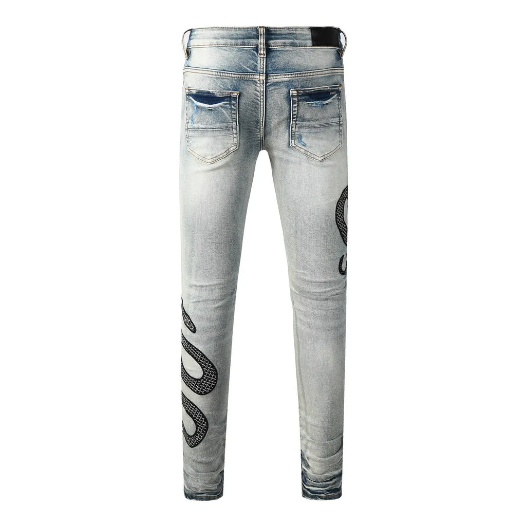Blue distressed skinny jeans with button fly and tapered leg in street fashion style