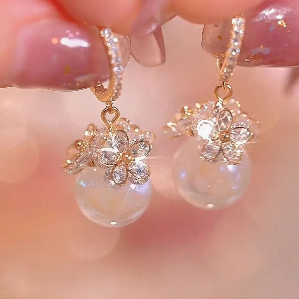 A pair of women's geometric copper earrings with a rose design and small zircon stone accents.