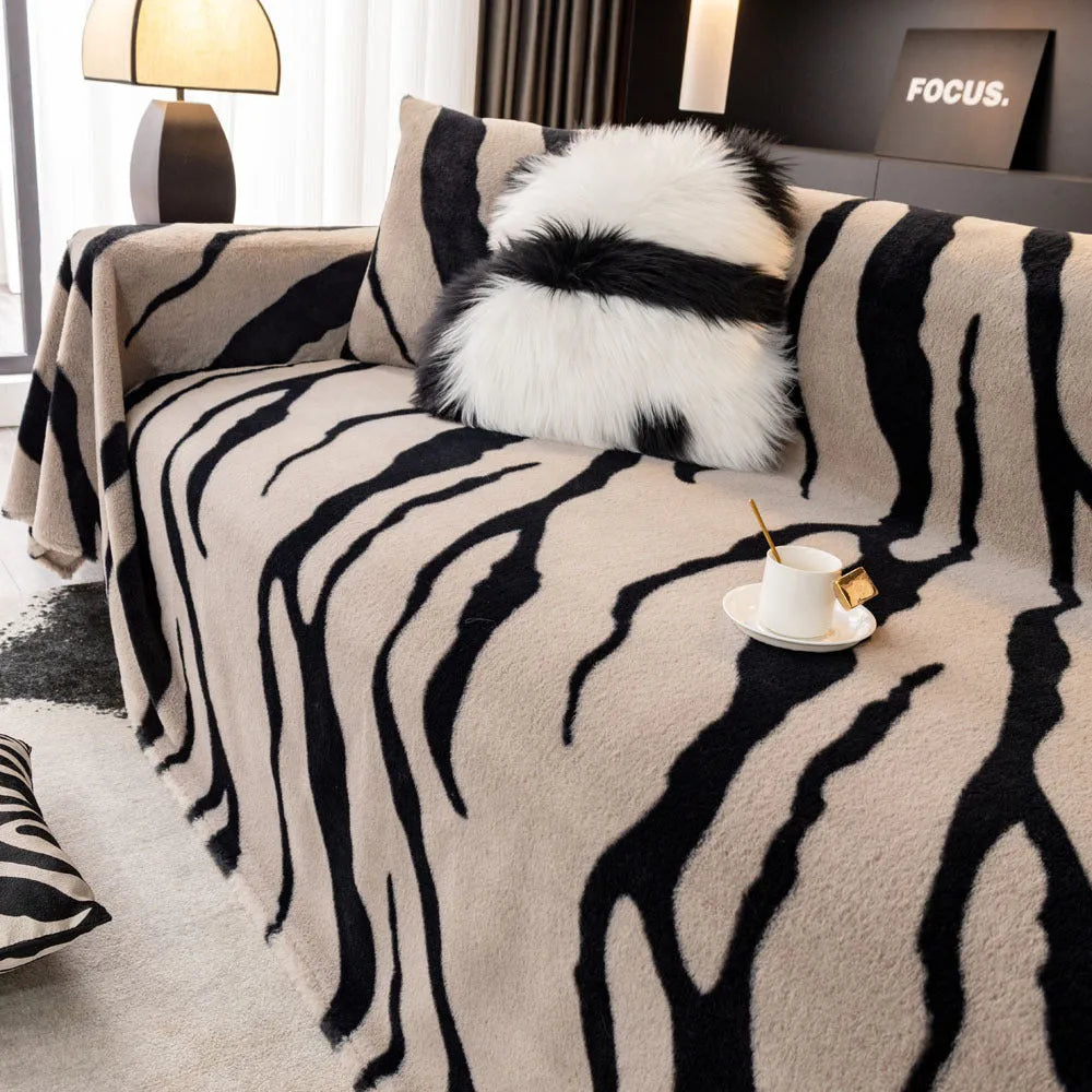 Zebra pattern flannel sofa slipcover in caramel colour, shown draped over a sofa with matching square pillow.