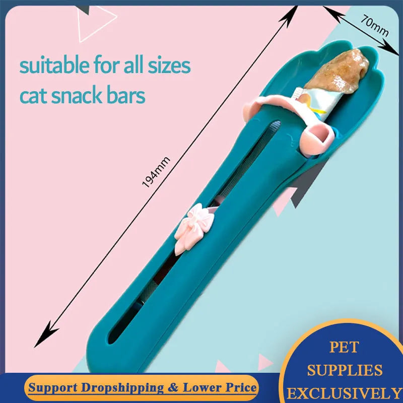 Green and pink pet food scooper spoon with squeezer handle and extruded feeder tip for dispensing treats.