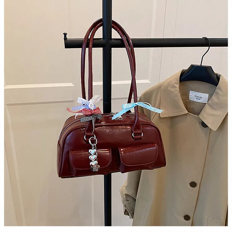 Retro one-shoulder pillow handbag in PU leather, shown in black with a flap closure and double straps.