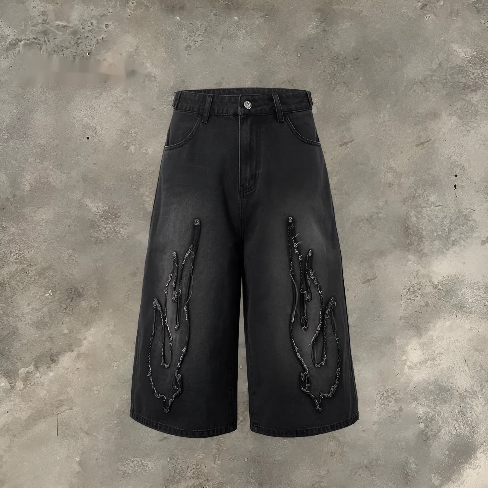Men's black denim shorts with flame embroidery patches on the legs, showing a cropped, straight-leg cut.