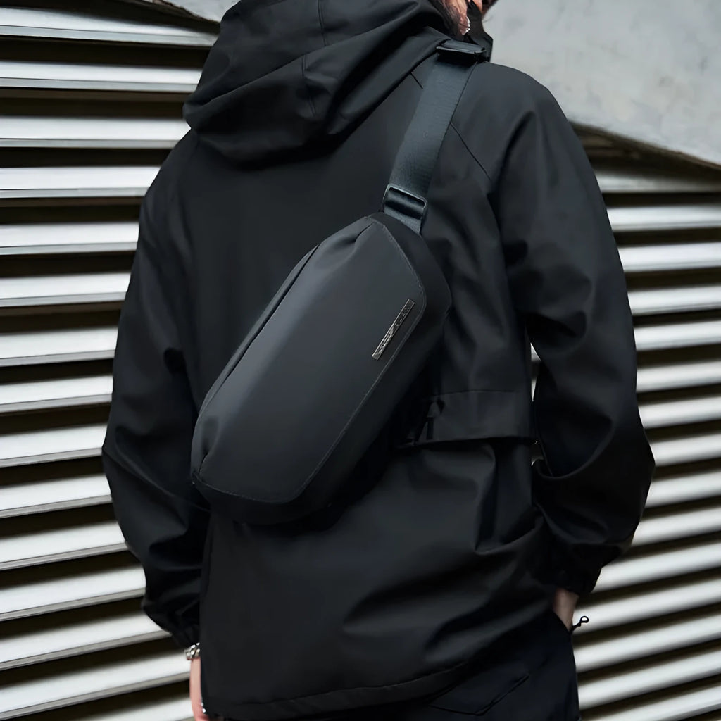 Black men's Oxford cloth messenger bag with cross-body strap showing sewing thread detailing