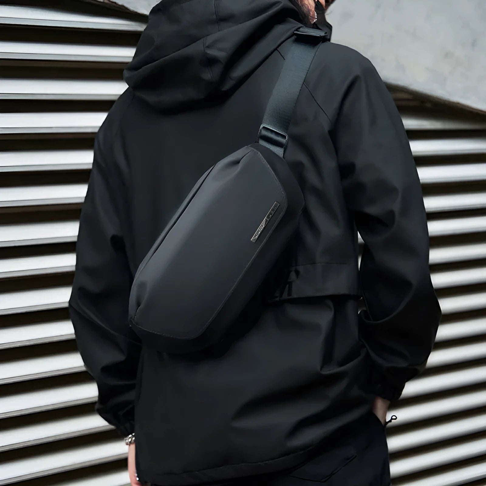 Black men's Oxford cloth messenger bag with cross-body strap showing sewing thread detailing