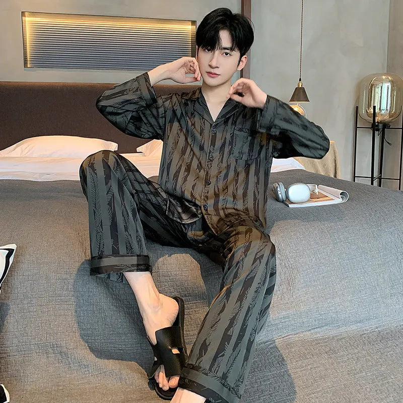 Men's black striped Ice Silk long sleeve V-neck pajama top and thin trousers set laid flat.