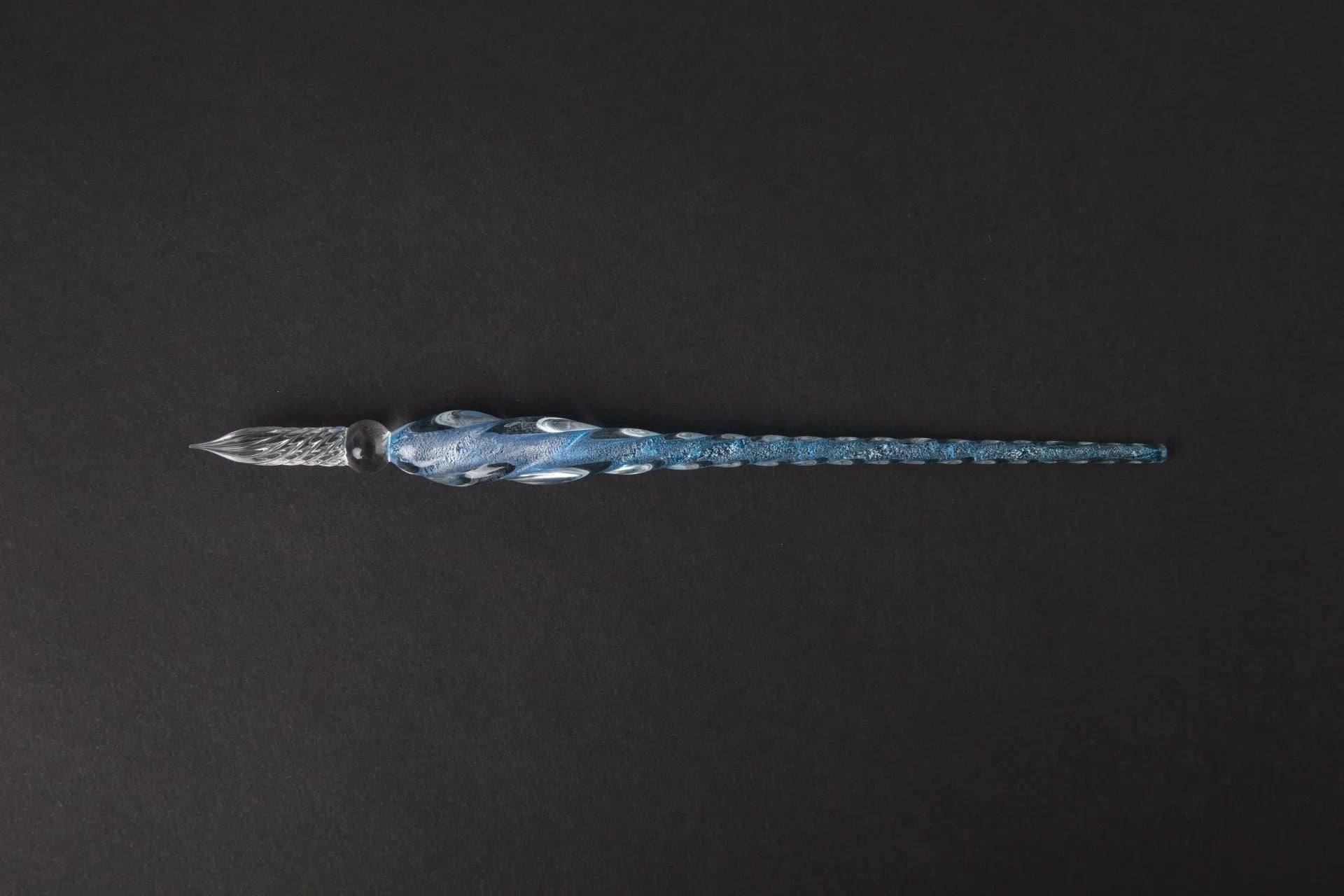 Hand-blown glass crystal pen with coloured ink in a transparent barrel on a gift box.